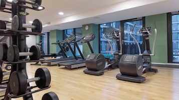 A gym with treadmills, elliptical machines, and weightlifting equipment.