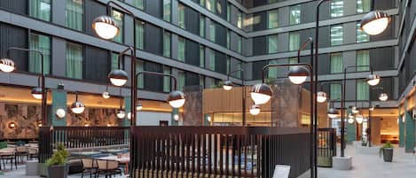 Un espacio interior moderno con varios niveles, ventanas amplias y luminarias contemporáneas.