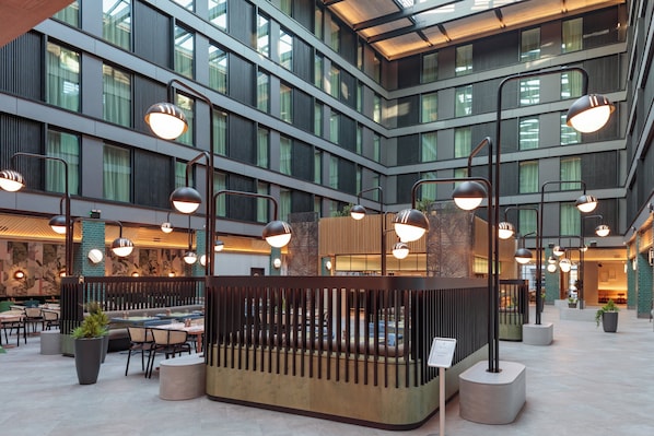 Un espacio interior moderno con varios niveles, ventanas amplias y luminarias contemporáneas.