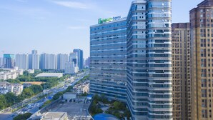 A high-rise hotel with a curved facade, multiple floors, and a prominent hotel sign.