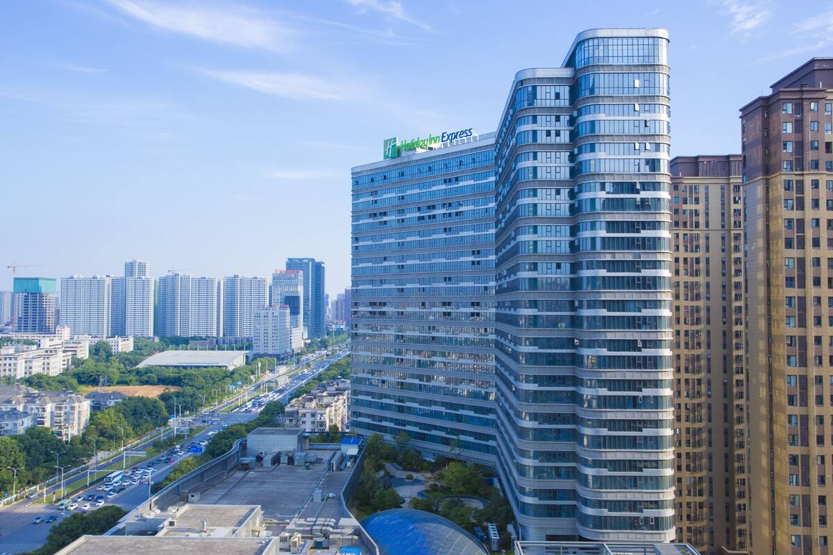 A high-rise hotel with a curved facade, multiple floors, and a prominent hotel sign.