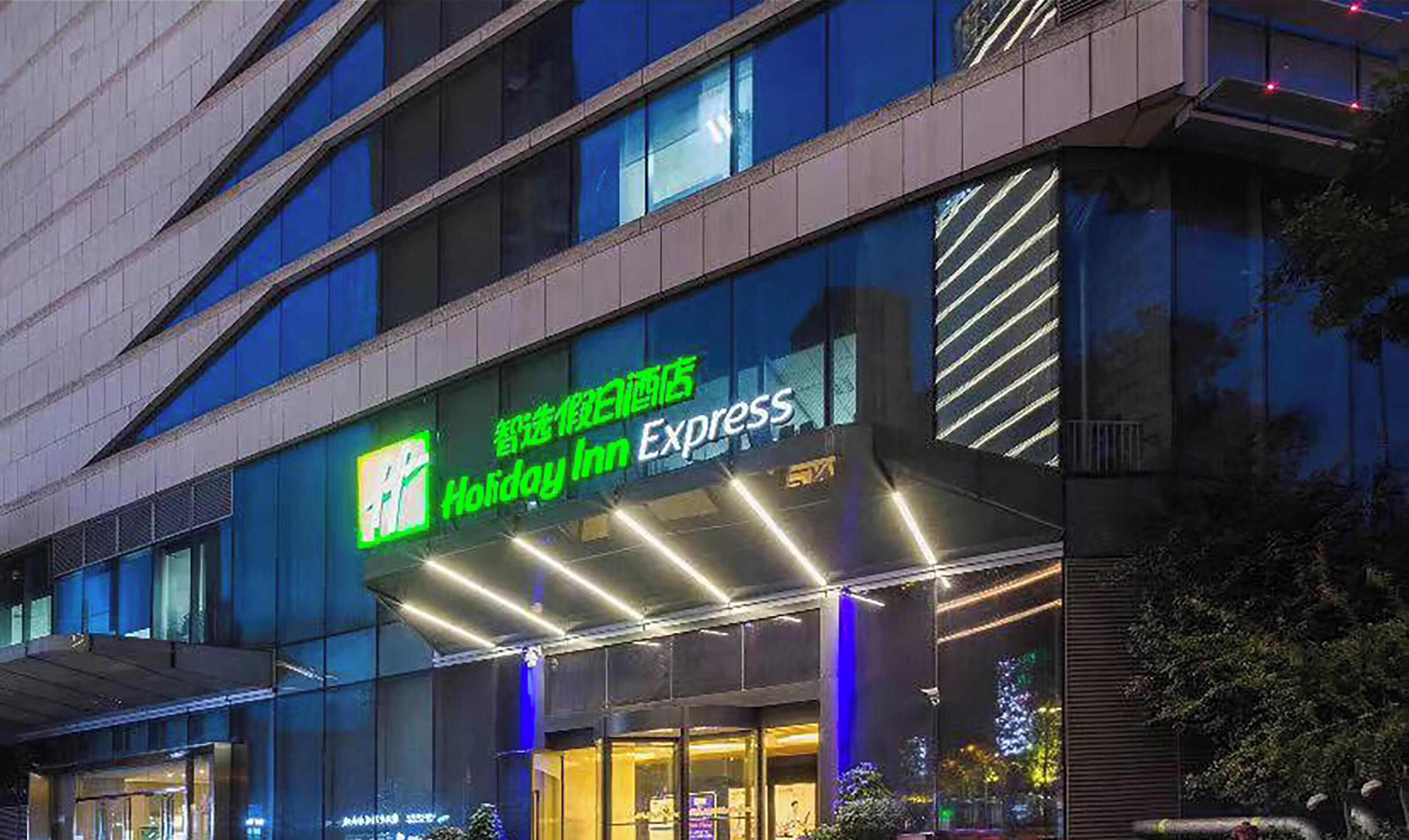 A Holiday Inn Express building facade with signage and lighting.