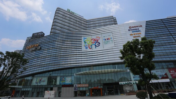 A modern hotel with a curved facade, large glass windows, and multiple signage including a prominent Holiday Inn Express sign.
