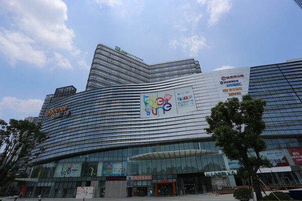 A modern hotel with a curved facade, large glass windows, and multiple signage including a prominent Holiday Inn Express sign.