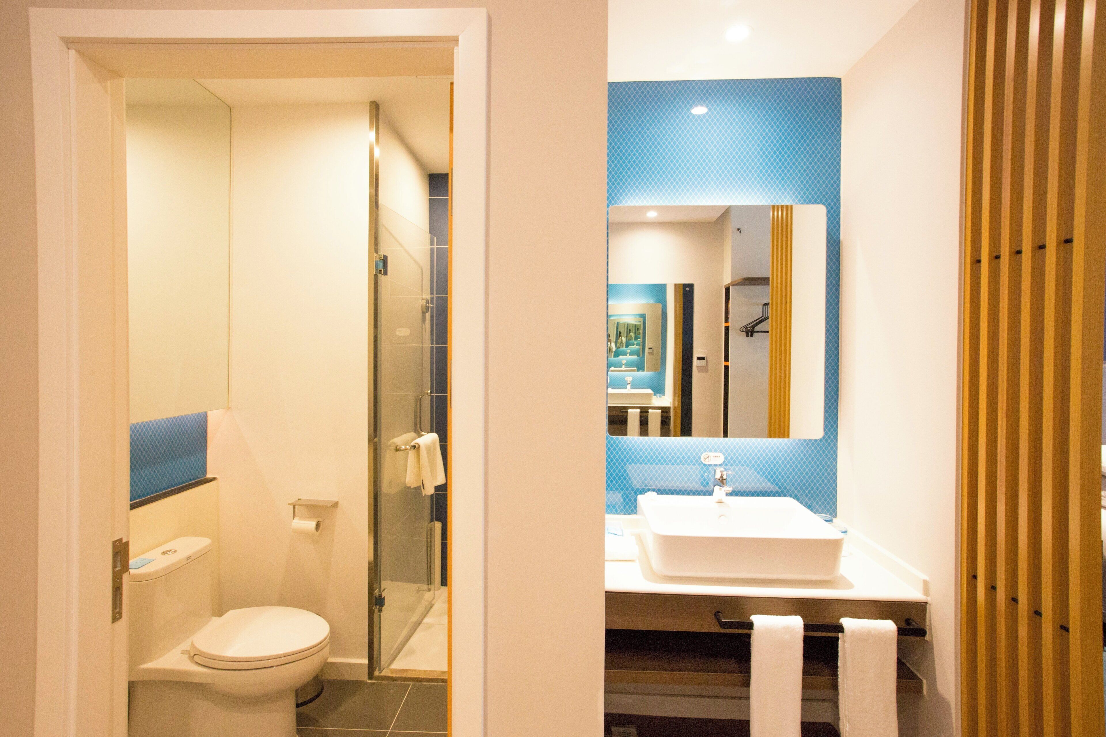 Un baño moderno con inodoro, ducha y lavamanos.