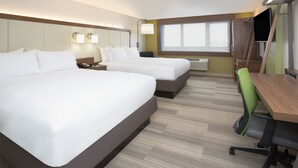 Habitación de hotel con dos camas, un escritorio, una silla, un televisor y una ventana.