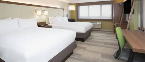 A hotel room with two beds, a desk, a chair, a TV, and a window.