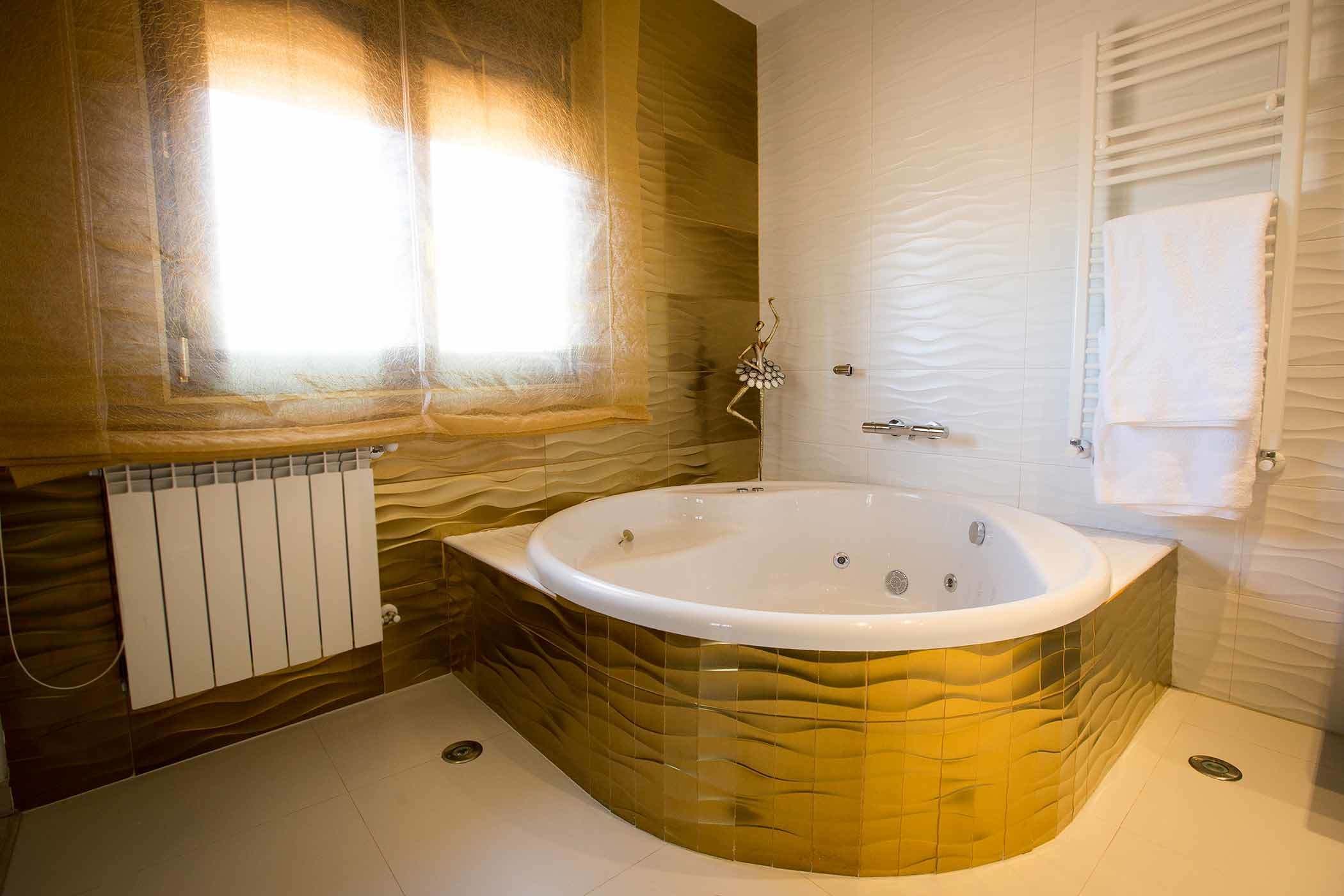 Une salle de bain moderne avec une grande baignoire ovale, une fenêtre avec des stores, un porte-serviettes et un radiateur.