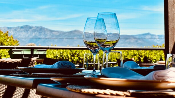 A table set with two wine glasses, a folded napkin, and a plate, overlooking a mountainous landscape. - Villa Xarahiz (Jaraíz de la Vera)