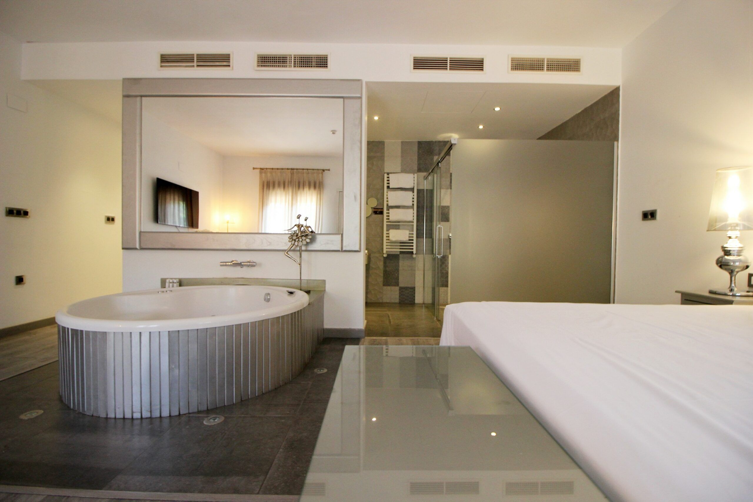 Une salle de bain moderne avec une grande baignoire, un miroir et un espace douche.