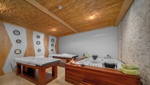 Un cuarto de spa con bancos de madera, una bañera grande y un tocador de madera con toallas.