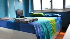 A room with a bed, a television, and a window with a view. - Dreamcatchers (La Spezia)