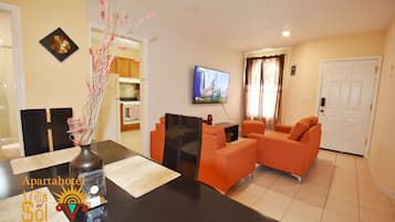Departamento Deluxe, 2 habitaciones, planta baja | Área de sala de estar | Smart TV de 65 pulgadas con canales vía satélite, televisión y Netflix