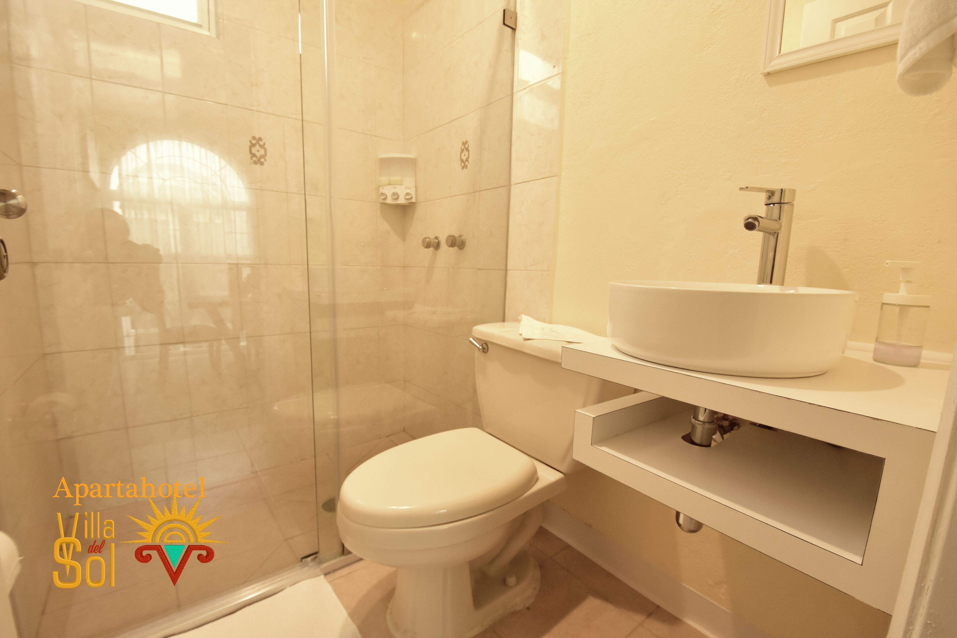 A bathroom with a toilet, a sink, and a shower enclosure.