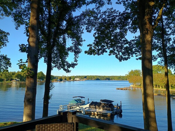 A lake with boats docked, surrounded by trees and a clear sky.