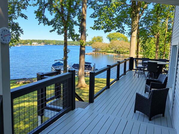 Une terrasse dotée d’une rambarde, de mobilier d’extérieur et offrant une vue sur un lac.