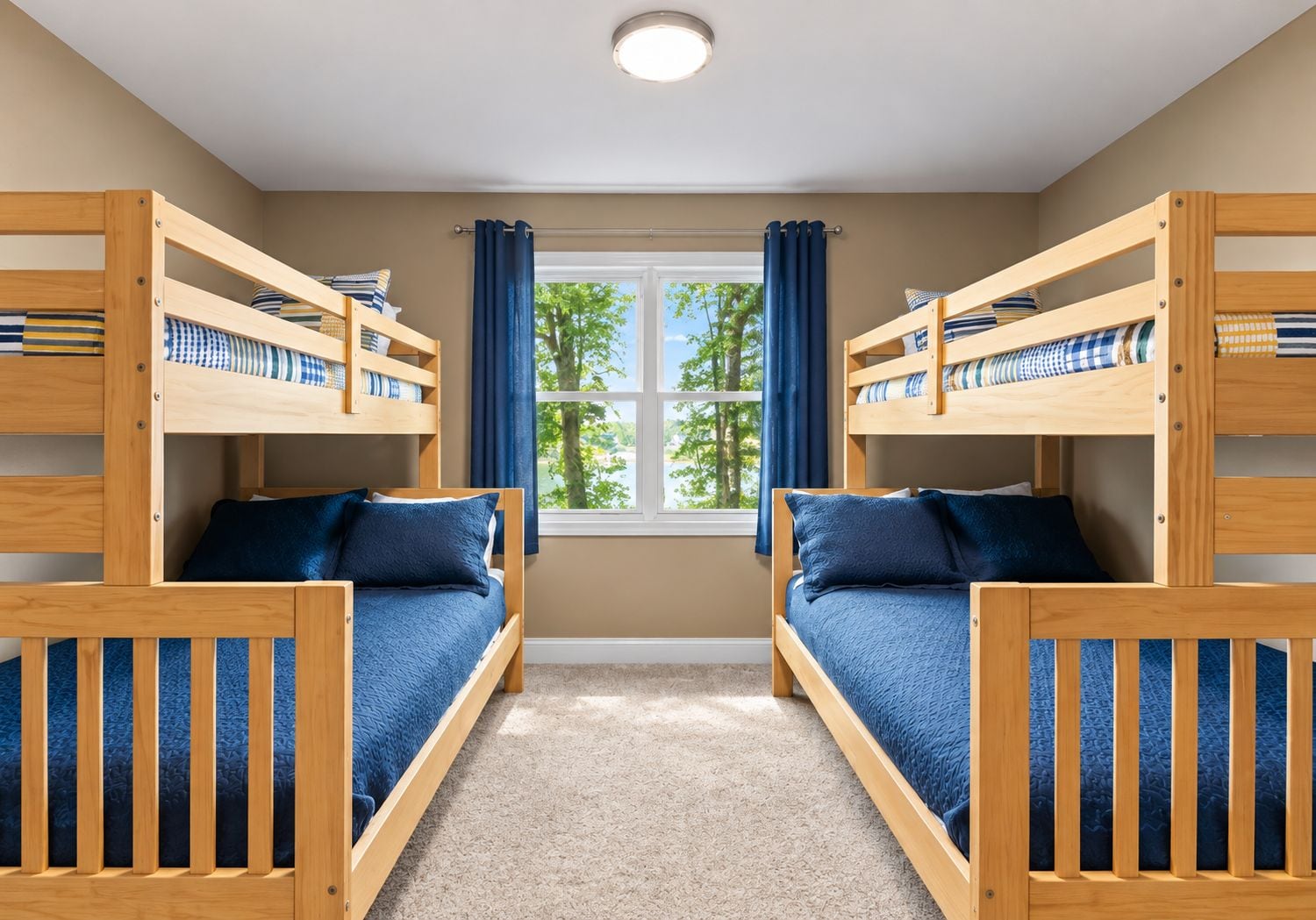 A room with two bunk beds, a window with curtains, and a carpeted floor.