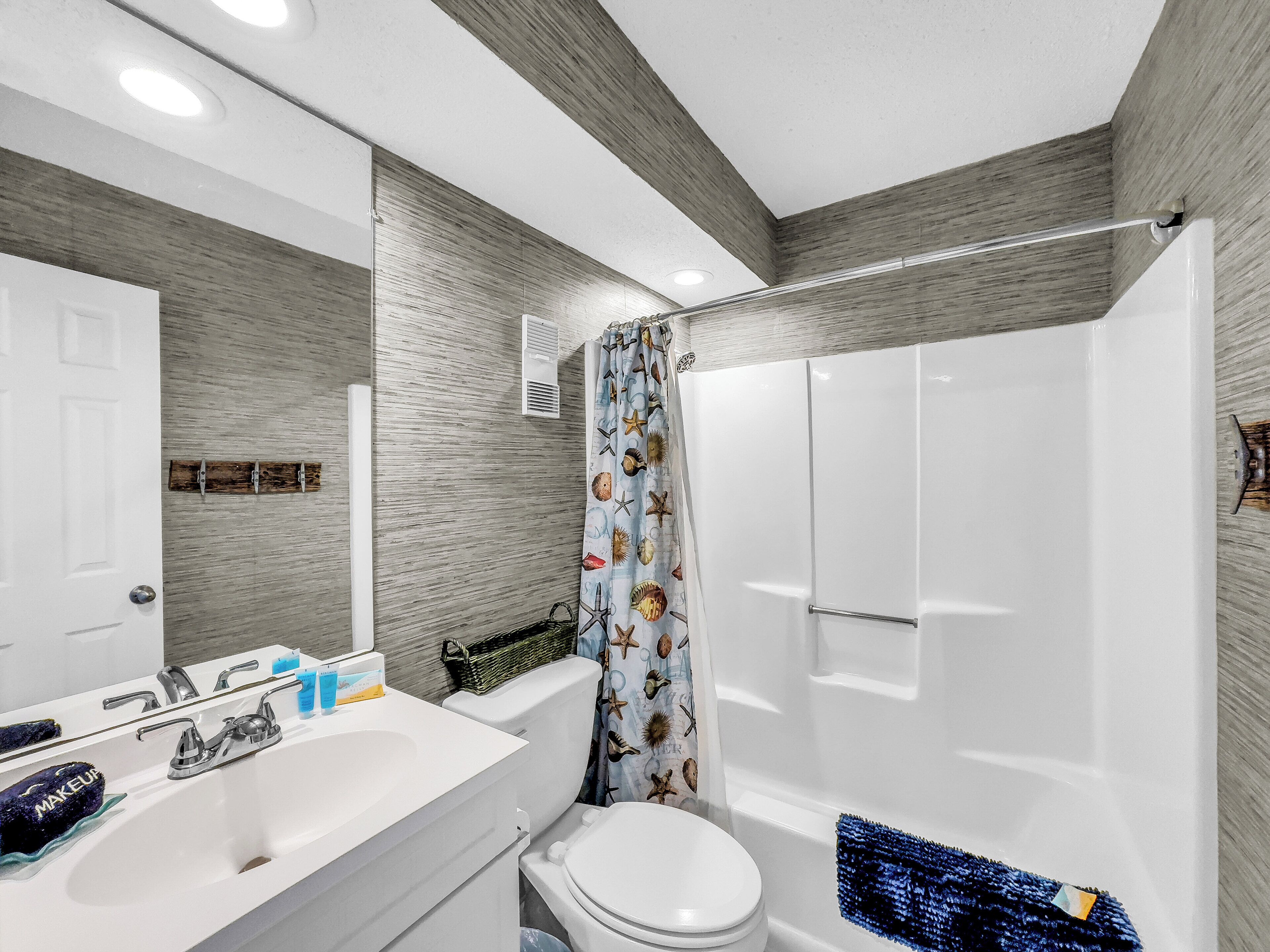 Un baño moderno con lavamanos, inodoro y bañera blancos.
