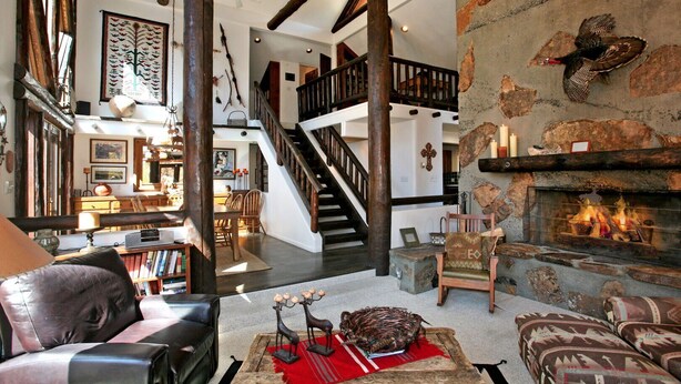 Amplia sala de estar con chimenea, una escalera y un comedor.