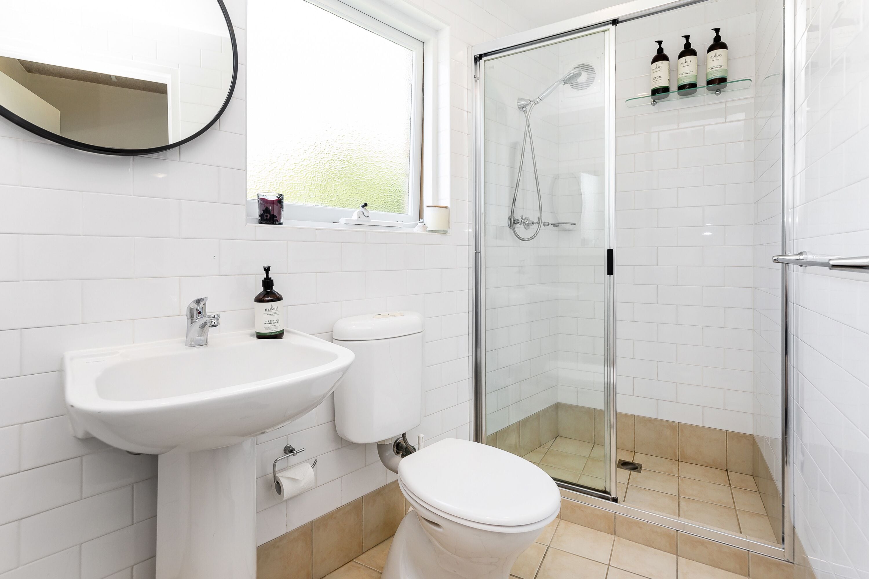 Ein modernes Badezimmer mit Waschbecken, Toilette und Duschkabine aus Glas.