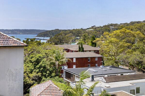 A residential area with houses, some with flat roofs and others with sloped roofs, surrounded by greenery and trees. - Balmoral Escape - footsteps from beach (Mosman)
