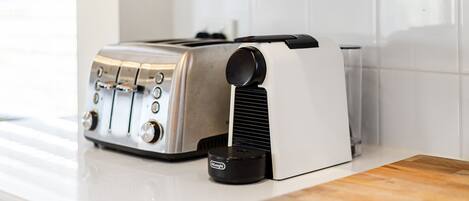 A kitchen with a toaster and a coffee maker on the counter.
