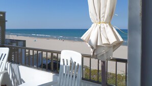 A balcony with a view of the beach, white chairs, and a white umbrella. - Apartment/ flat - DeniaResidential flat (Denia)