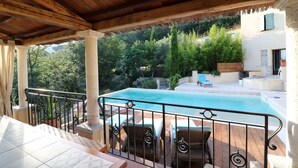 A covered outdoor area with a pool, wooden deck, and outdoor seating. - Exceptional luxury house, poolhouse area and heated swimming pool (Seillans)