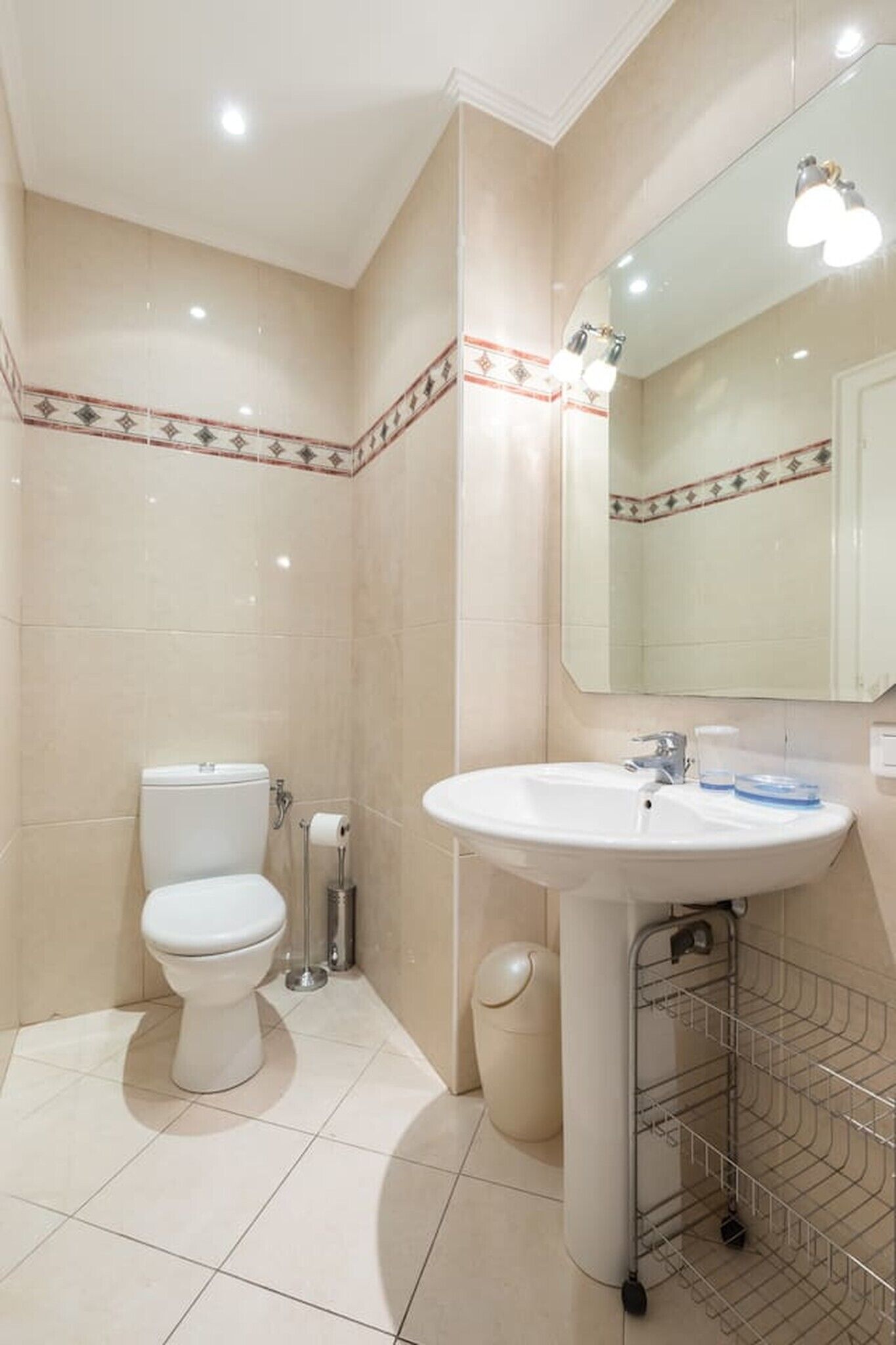 Une salle de bain avec des toilettes, un lavabo et un miroir.