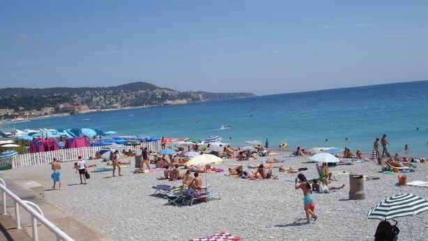 A crowded beach with people sunbathing and swimming, umbrellas, and beach chairs. - WATERFRONT PANORAMIC Seaview 2bd/2bath Apt on Promenade Des Anglais by Negresco  (Nice)