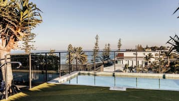 A rooftop pool with a clear view of the sea and surrounding buildings.