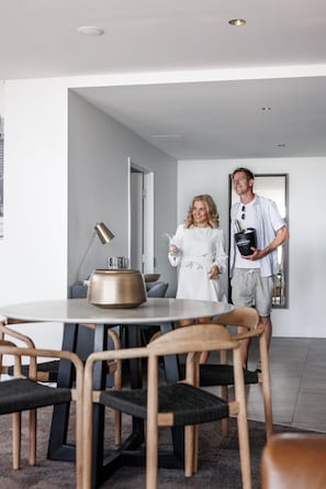 A modern dining area with a round table, chairs, and a lamp. - The Sebel Brisbane Margate Beach (Margate)