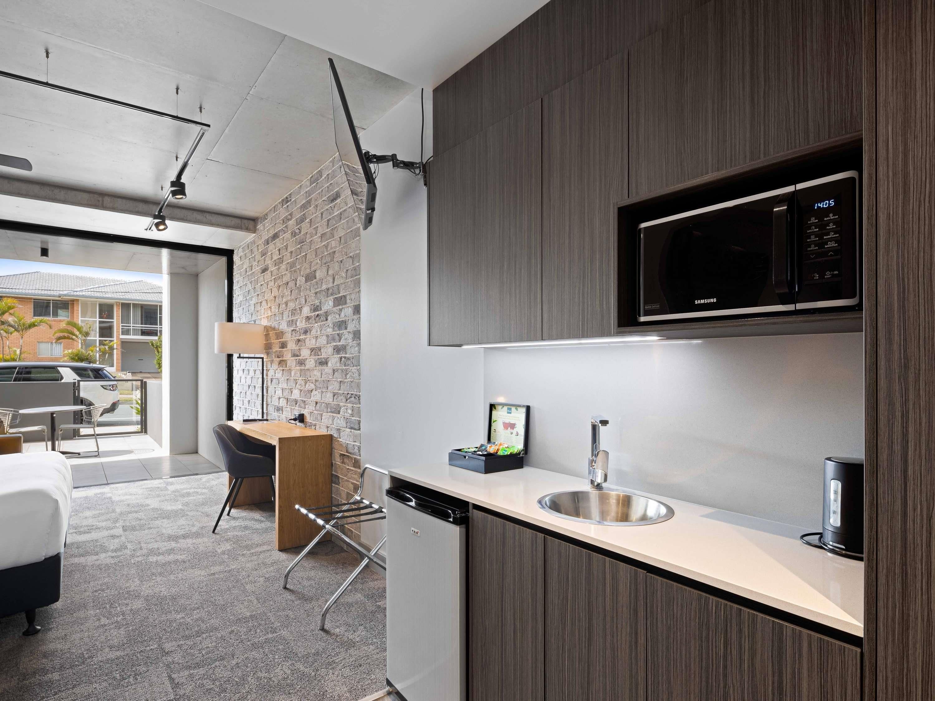 A modern kitchen with a built-in microwave, a sink, and a dishwasher.