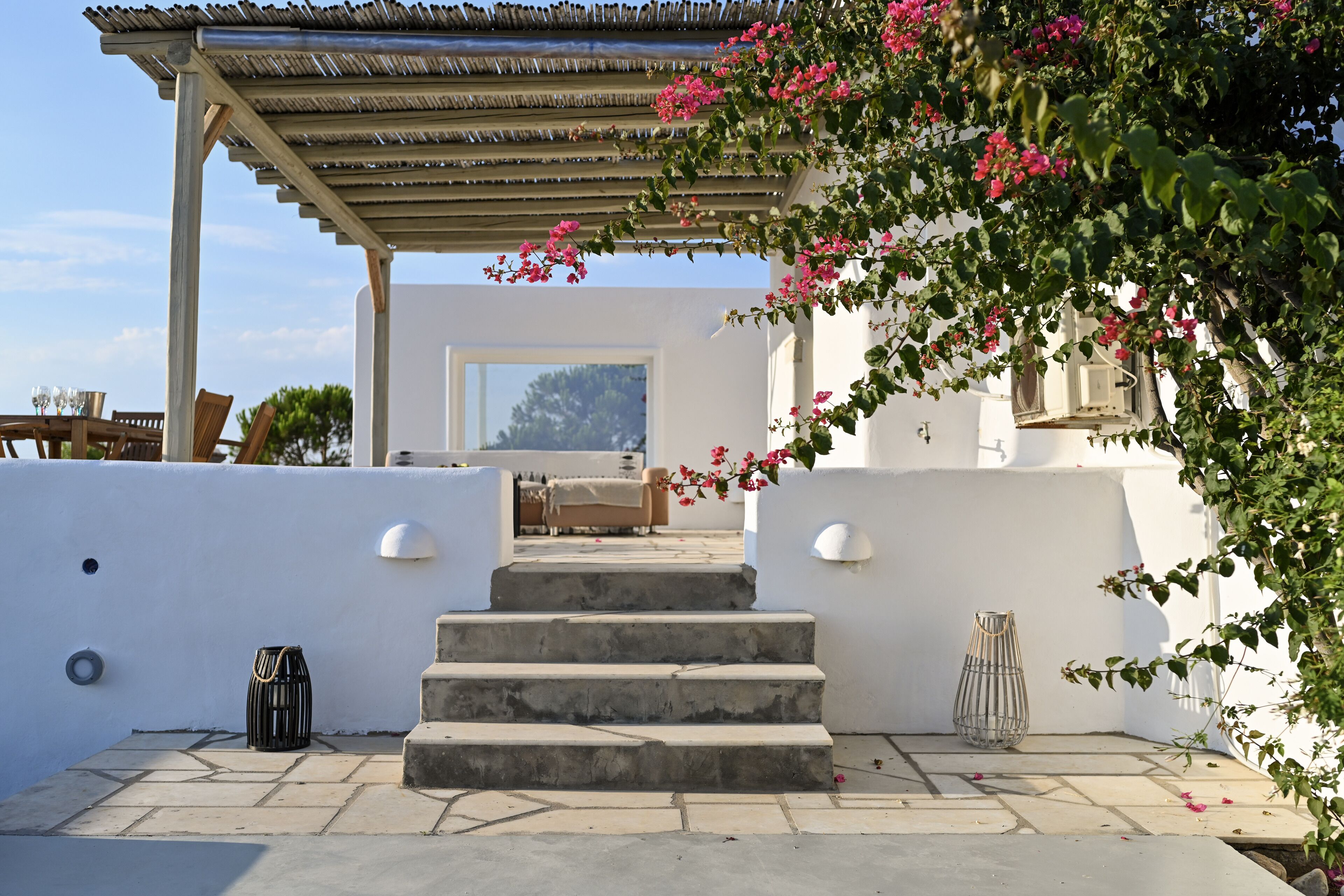 A covered outdoor area with a set of stone steps leading to a seating area.