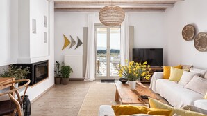 Un salon moderne avec une cheminée, un canapé, une table basse et une grande fenêtre offrant une belle vue.