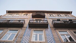 A building with a tiled facade, multiple windows, and balconies.