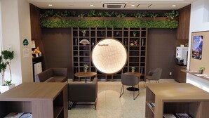 A reception area with a map display, seating, and a plant wall. - Green Hotel Yes Nagahama Minatokan (Nagahama)