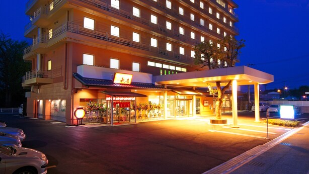 A multi-story hotel with a ground-level entrance, balconies, and a well-lit facade. - Green Hotel Yes Nagahama Minatokan (Nagahama)