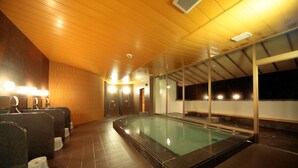 A swimming pool with a wooden ceiling and tiled floor, surrounded by benches and a glass wall. - Green Hotel Yes Nagahama Minatokan (Nagahama)