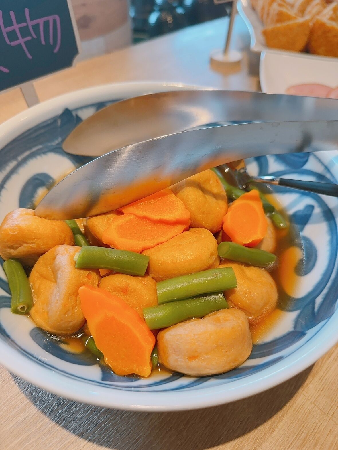 A bowl of food with vegetables and a spoon.