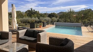 Área de piscina com móveis de vime e vista para a paisagem ao redor.