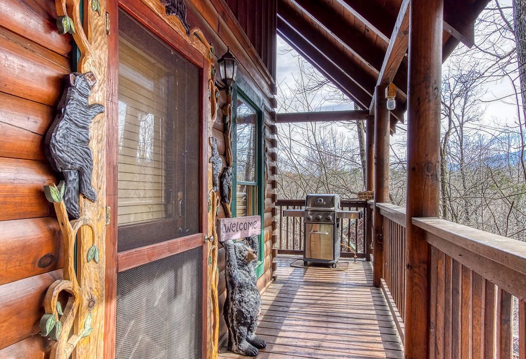 A wooden cabin with a porch, a grill, and a 'Welcome' sign.