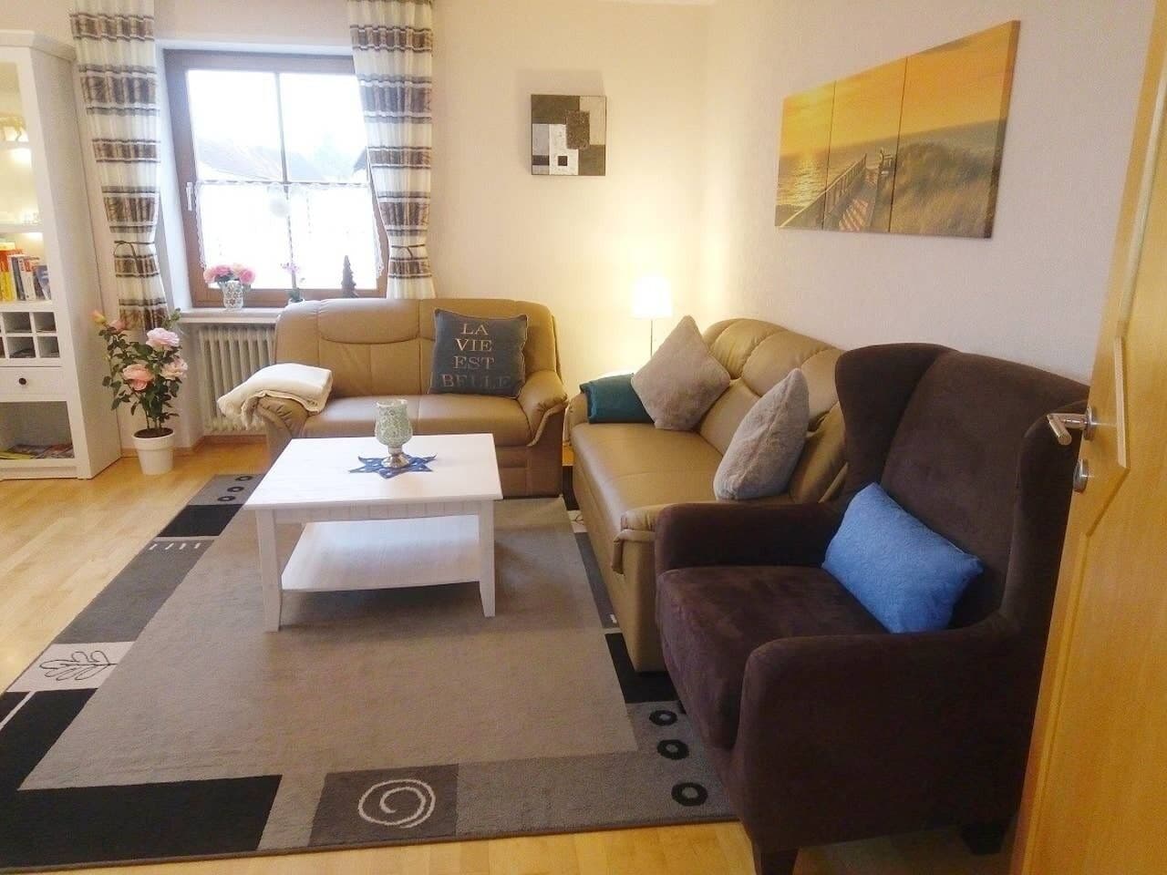 A living room with a sofa, armchair, and coffee table.