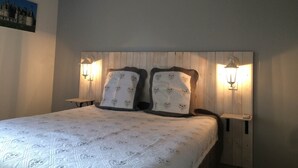 A bedroom with a wooden headboard, two bedside lamps, and a quilted bedspread. - La Haute Bédinière, B&B near Chambord (Crouy-Sur-Cosson)