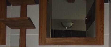 A stone sink with a brass faucet mounted on a wooden countertop.