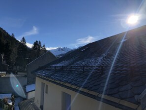 Ein Gebäude mit schrägem Dach, kleinem Fenster und sichtbarer Tür.
