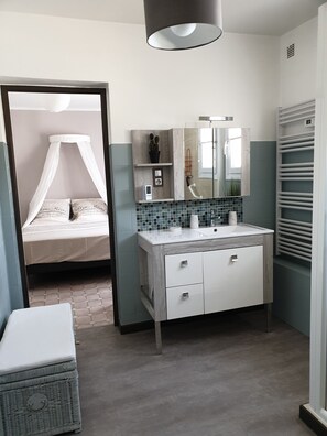 Een moderne badkamer met een wastafel, spiegel en douche.