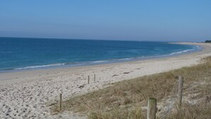 A sandy beach with a clear blue sky and calm sea. - The home of the Moulin de Kérangoc (Melgven)