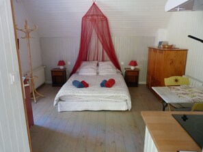 Una camera da letto con un letto, un comodino, un armadietto in legno, un tavolo e una sedia.