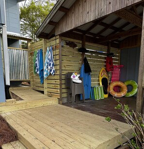 Guests can enjoy a storage area with a deck and ramp, featuring a pool, kayak, and comfortable seating.